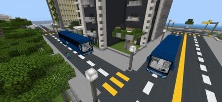 Пара синих элегантных автобусов на перекрёстке улицы