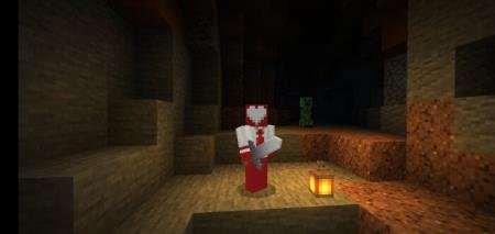 Игрок, с головой в виде сердца, стоит посреди пещеры, освещённой одним лишь фонарём