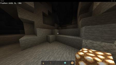 Игрок со светящимся блоком в руке освещает пространство в пещере