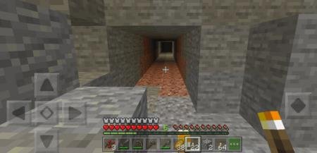 Игрок с факелом смотрит на сквозной проход в пещеру