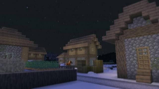 Вид на снежную деревню в ночи