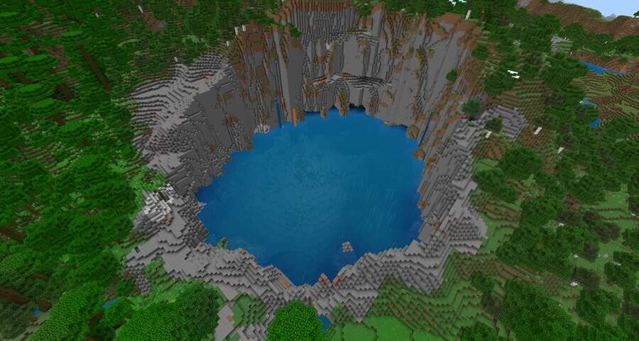 Озеро на дне кратера посреди гор на фоне леса