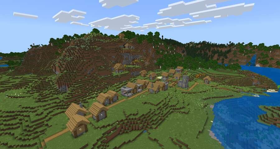 Деревушка на фоне речки и высоких гор