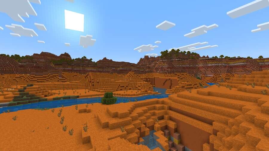 Оранжевые дюны на фоне речки и синего неба