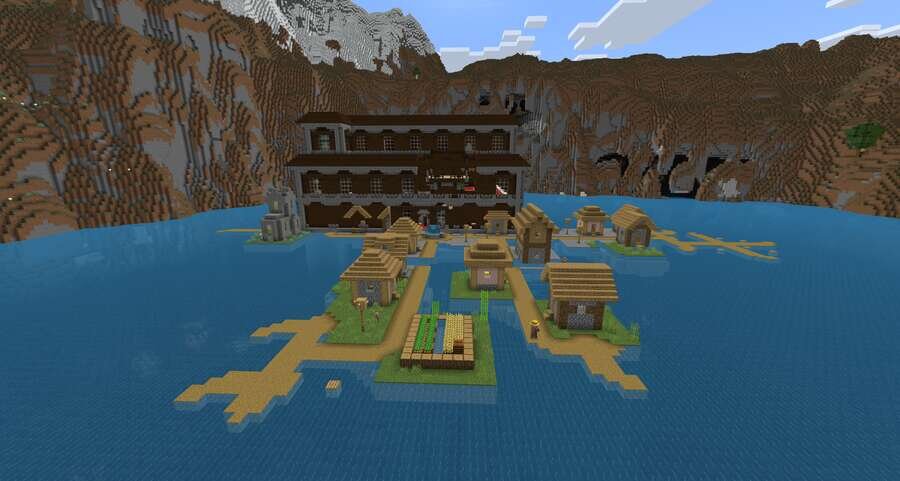 Вид на особняк и речку с деревней на фоне высоких гор