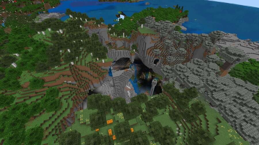 Вид на глубокую пещеру сверху на фоне леса и воды