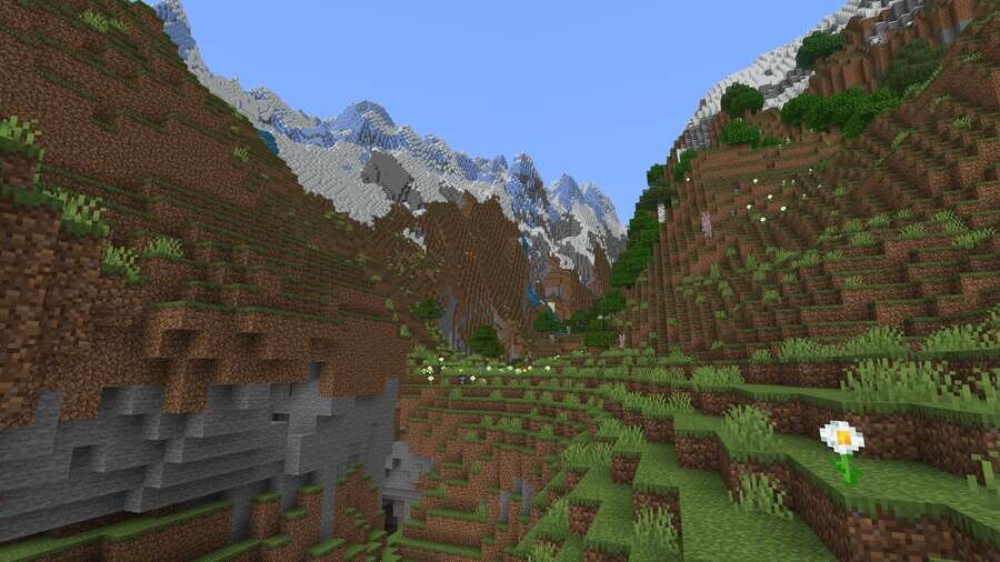 Вид из долины на высокие горы на фоне синего неба